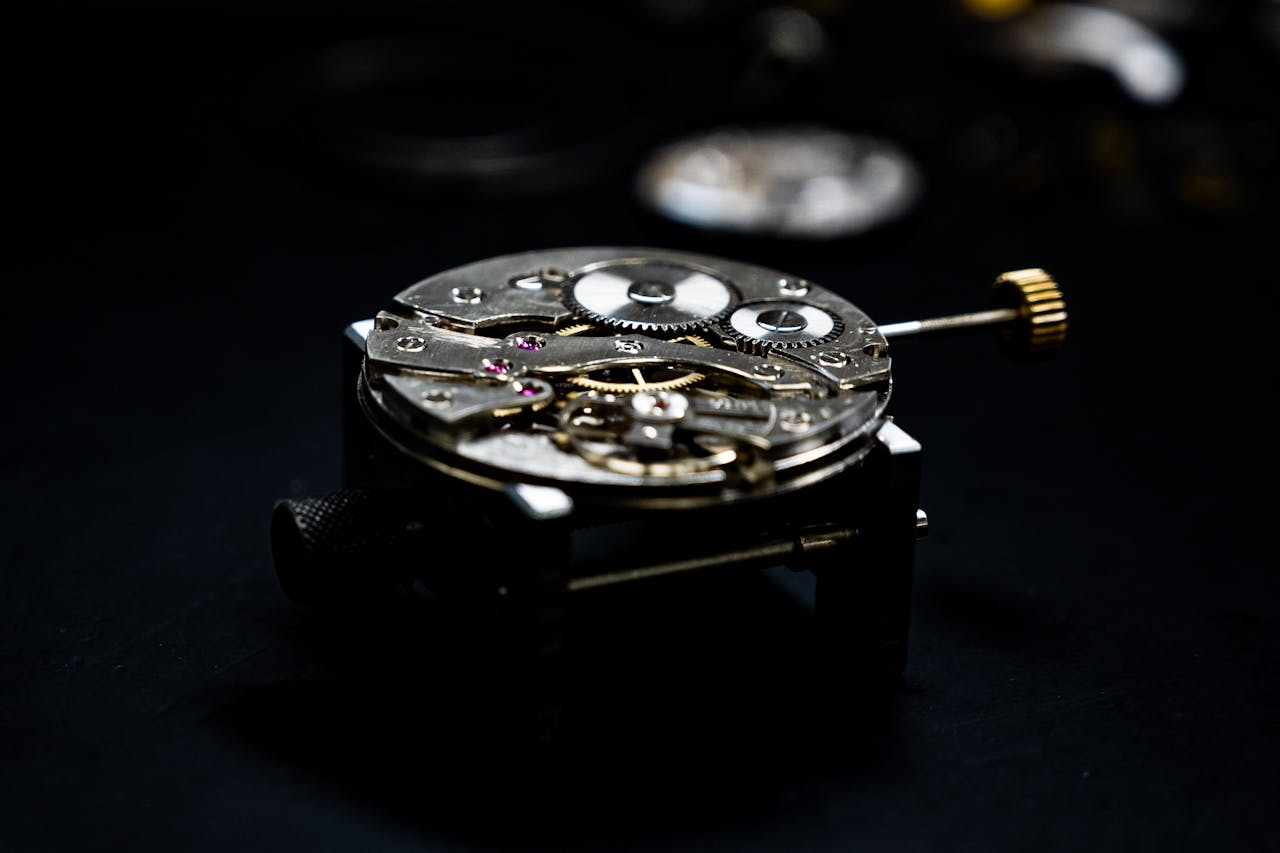 Close-up of a detailed watch mechanism showcasing gears and components against a dark background.